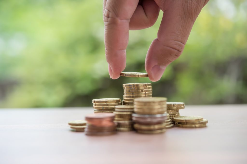 Saving Money Concept . Hand Putting Money Coin Stack