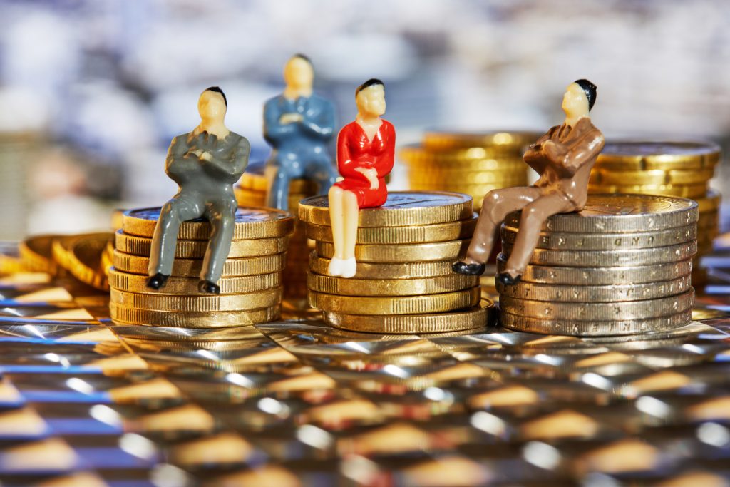 The Coins Are Stacked On Top Of Each Other With The Figures Of Business People Sitting On Them, A Market Crisis And A Fragile Market
